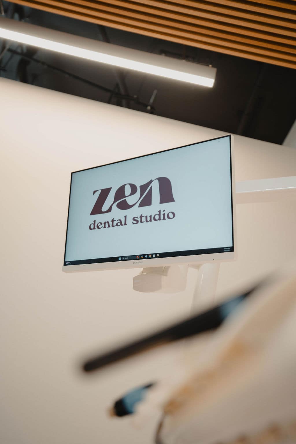 The Zen Dental Studio brand on a treatment-room display, warm wood overhead